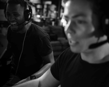 Two people laughing while playing a video game together