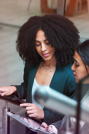 Two people on a staircase reviewing work documents