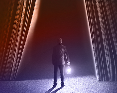 Man holding a lamp trying to light a dark path