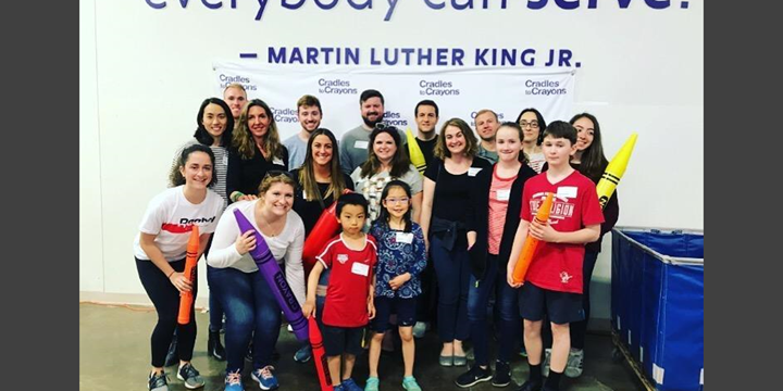 Lionbridge Waltham team group photo posing with kids from Cradles to Crayons