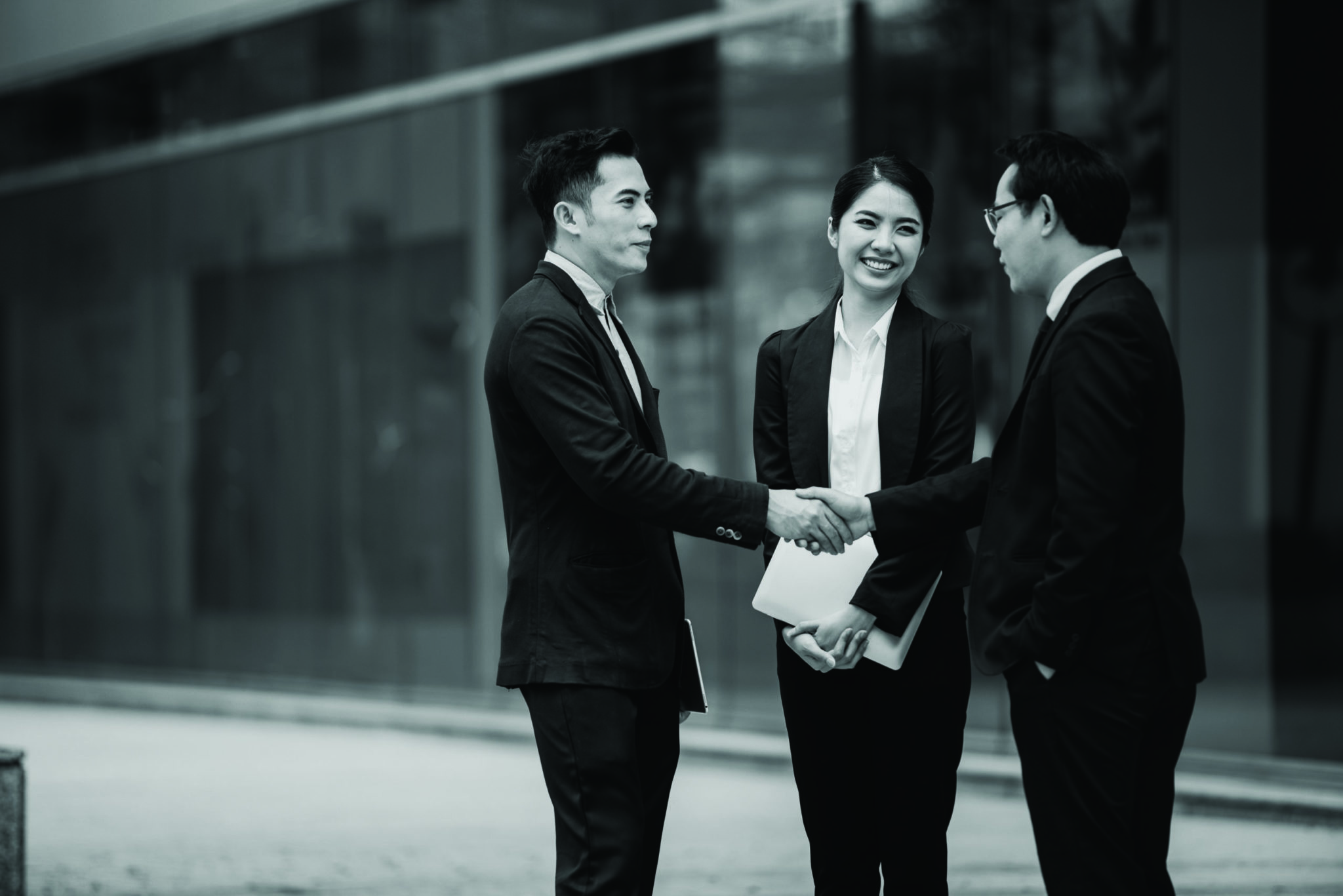 Japanese business people shaking hands outside building, the definition of Japanese word Yoroshiku Onegaishimasu