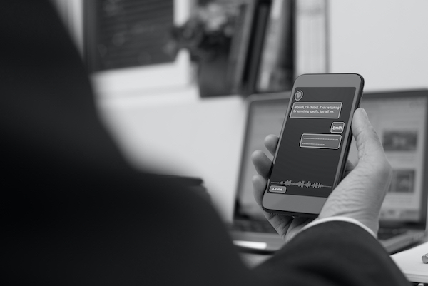 Businessmann nutzt Chatbot auf Mobiltelefon