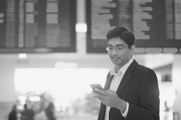 Millennial in Indien der Informationen mit Smartphone sucht.