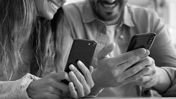 couple utilisant des smartphones, partageant du contenu amusant, regardant des photos ou des vidéos, jouant à des jeux en ligne