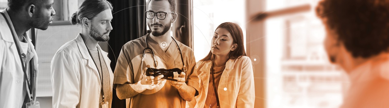 Researchers examining medical device together