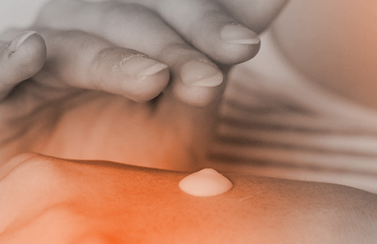 Woman putting skincare cream on the back of her hand