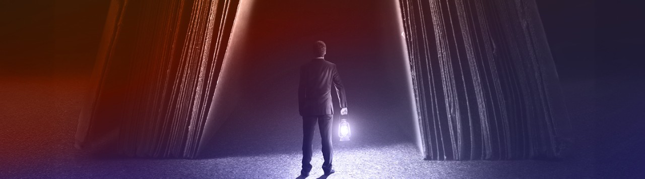 Man holding a lamp trying to light a dark path