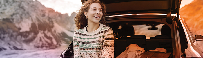 person sitting in the open truck of a car