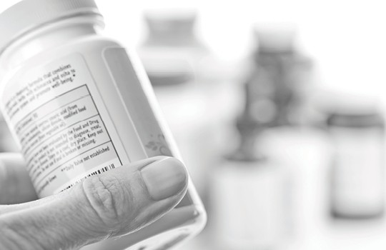 Patient holding a medicine bottle looking at label
