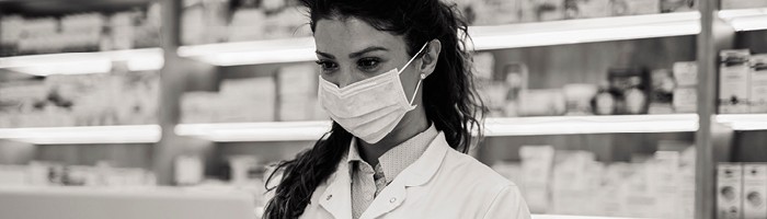 A woman wearing a mask in a pharmacy.