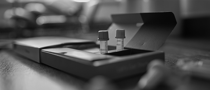 Two vials, possibly containing patient specimens, in a box.