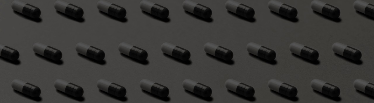 Rows of capsules on a grey background.