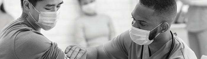 A medical practitioner administers a shot