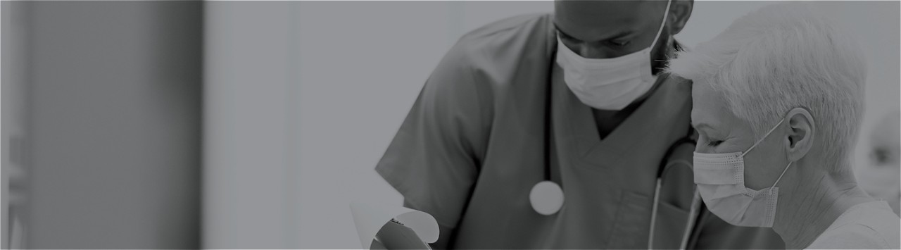 A medical practitioner and a patient examine a chart 