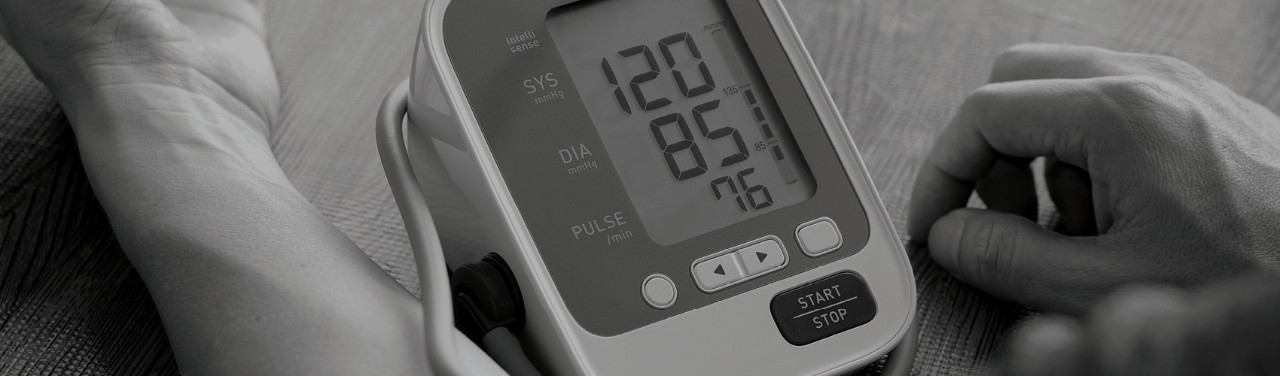 A patient takes their own blood pressure, as they would do when reporting biometrics for a remote clinical trial.