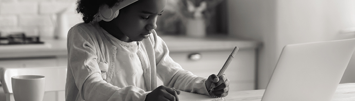 A girl doing schoolwork in front of a laptop