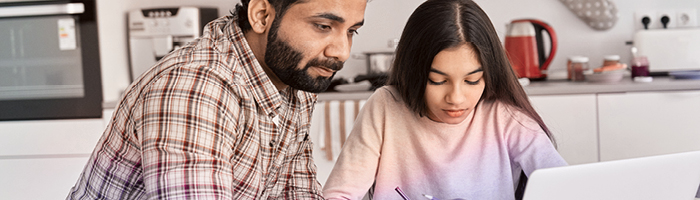 A man checking his daughter's homework 