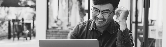 A man smiling at a laptop