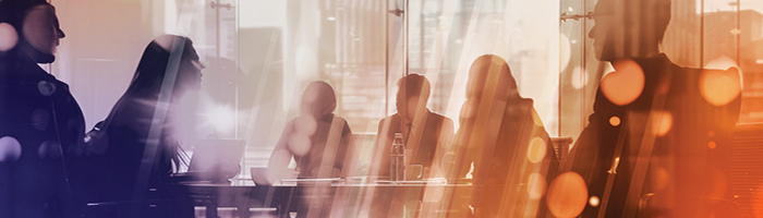 A team collaborates around a conference table to discuss vendor consolidation strategies.