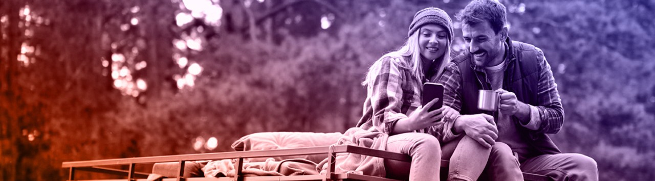 Travelers are enjoying a moment in nature, using a smartphone to plan their next adventure.