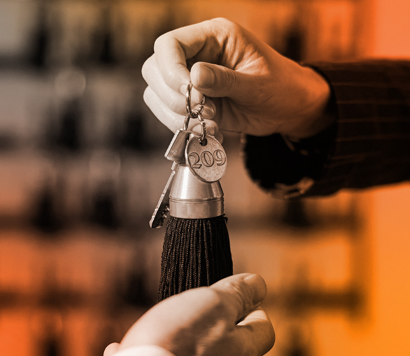 Person handing over a hotel room key