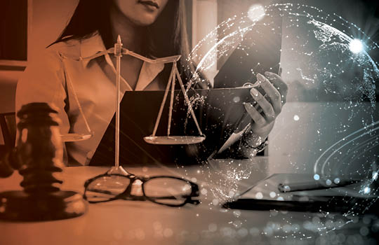 Person working on laptop with judicial scales