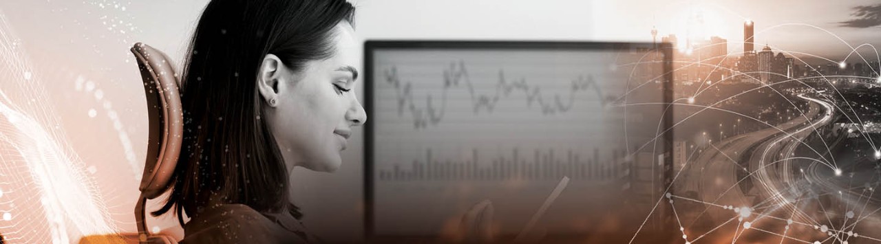 A person sits at a workstation using technology next to an image of a city, depicting the relationship between technology and modern society. 