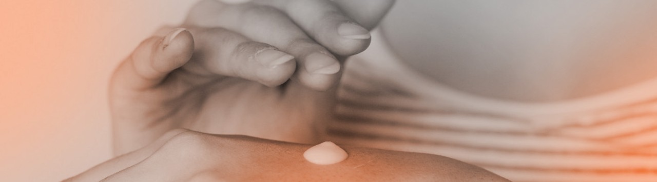 Woman putting skincare cream on the back of her hand