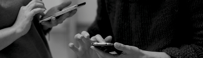 Two people checking their phones