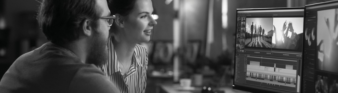 Two people working in video software editing program