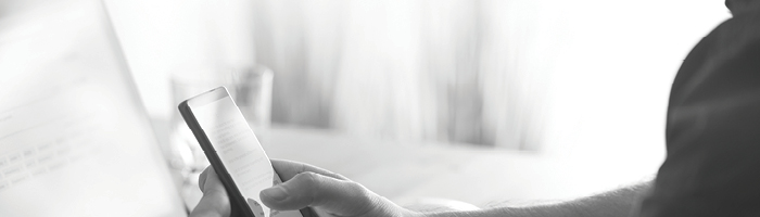 A profile view of someone using their phone in a sun-filled room.