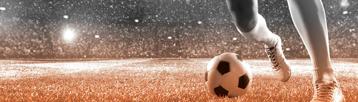 Footballer dribbling the ball in a stadium