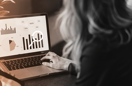 Person looking at laptop reviewing a chart and percentages for real-time reporting
