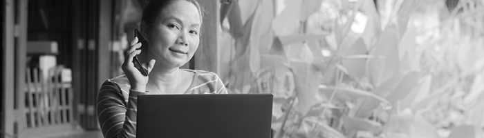 Woman taking a phone call while working on a laptop