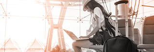 Traveller sitting in airport using laptop