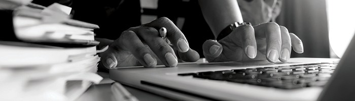 Close-up of person's hands typing on a laptop