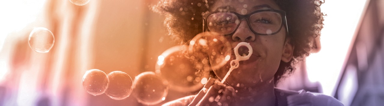 en glad person blåser såpbubblor