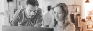 Man explaining work to a woman before a computer