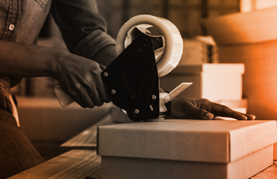 Person taping a shipment box