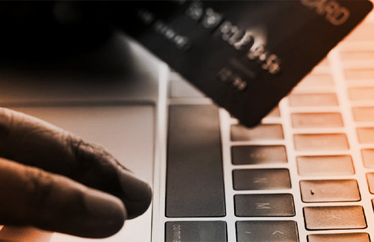 Person using laptop to make purchase with a credit card