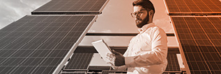 A person standing beside solar panels