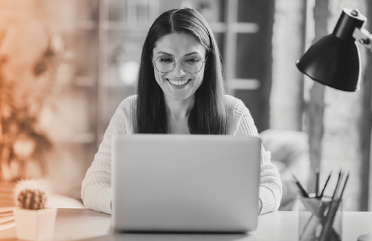 Woman smiling while working a laptop computer
